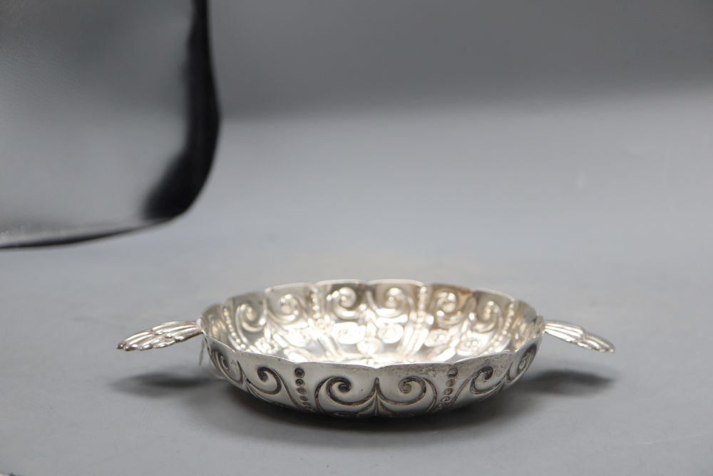 An Edwardian repousse silver shallow bowl, with fluted lug handles, Wakely & Wheeler, London, 1906, 24.7cm, 8.5oz.